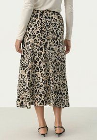 Leopardmönstrad midiklänning i lättviktsmaterial, med en utsvängd design och en mjuk textur i svart och beige färgpalett.
