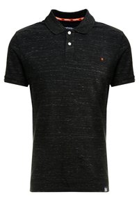 Polo noir en texture slub, avec un rabat à deux boutons et un discret logo sur la poitrine. Manches courtes avec des poignets ajustés.