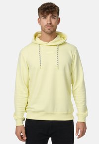Sudadera amarilla clara de tejido suave, con capucha ajustable, puños acanalados y una pequeña etiqueta rectangular en la parte frontal.