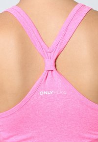 Top atletico rosa con vestibilità slim, caratterizzato da un design racerback e un dettaglio annodato sul retro. Logo "ONLY PLAY" visualizzato in bianco.