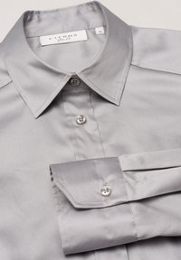 Gray, long-sleeve dress shirt with a pointed collar, smooth texture, and buttoned cuffs. Features two front buttons and ETERNA label.