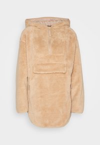 Pullover fluffy beige con cappuccio, dotato di zip a metà davanti e grande tasca frontale, caratterizzato da un orlo arrotondato e maniche lunghe.