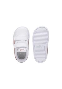 Zapatilla blanca con doble cinta de Velcro, suela de goma y forro interior gris. Presenta un acento rosa y suela antideslizante.