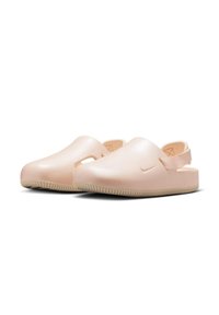 Zuecos de color rosa claro, hechos de plástico suave, con una correa trasera, lados con recortes y suelas moldeadas con un patrón de agarre texturizado.