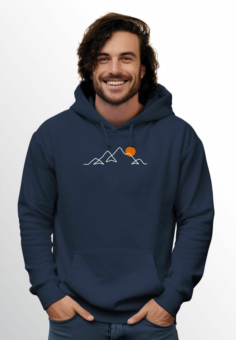 Marineblauer Kapuzenpullover mit einer frontalen Tasche, ausgestattet mit einem weißen Berggrafik und einem orangefarbenen Sonnendetail. Glatte Textur, lässiges Design.