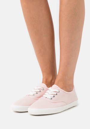 Vaaleanpunaiset kangaskengät, joissa on valkoiset nauhat ja kumipohja. Pyöristetty kärki ja minimalistinen muotoilu. Sileä pinta, jossa on hopeiset nyörit.