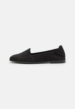 Sorte slip-on sko i ruskind med rundet tå og minimalistisk design. Har flad gummisål og glat tekstur.