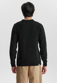 Schwarzer Strickpullover mit langen Ärmeln und rundem Halsausschnitt, ausgestattet mit gerippten Bündchen und Saum. Strukturierter Stoff mit einem subtilen Glanz.