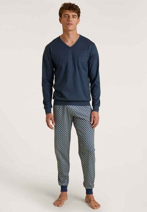 Marineblauwe long sleeve V-hals shirt met eenzakje, gecombineerd met gestreepte pyjamabroek in blauw, wit en groen. Broek heeft omslagbanden bij de enkels.