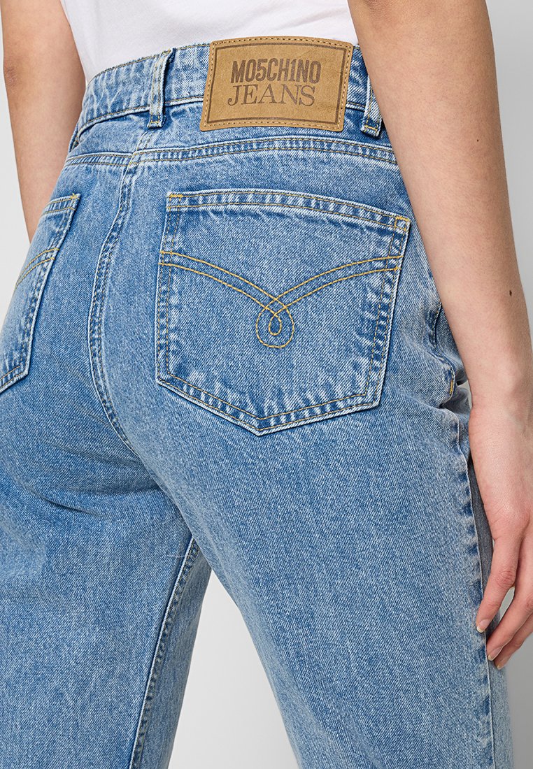 Jasnoniebieskie dżinsy z wysokim stanem o wyblakłym wykończeniu, z brązową skórzaną metką marki i charakterystycznym przeszyciem tylnej kieszeni.