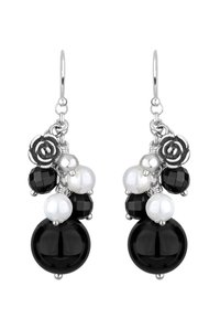 Boucles d'oreilles noires et blanches en perles, avec des perles rondes et facettées, des accents métalliques et un détail de charme floral. Matériel en ton argent.