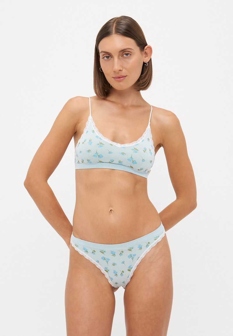 Floral-patterned light blue bralette and matching panties, made from soft ribbed fabric with white lace accents along the edges.