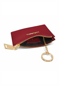 Portafoglio in pelle rossa con finitura testurizzata, zip dorata e anello per keychain. Il compartimento interno presenta una fodera nera e un logo impresso.