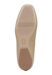 Suola piatta di scarpa in beige con una finitura liscia, caratterizzata da scanalature orizzontali per garantire grip e un logo inciso discreto sul lato.