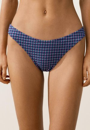 Ženska, oblečena v spodnji del bikinija vijolične in modre karo vzorce, z teksturiranim vzorcem, prikazana od sredine trupa do zgornjega dela stegen.