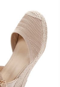 Espadrillas beige con un upper intrecciato testurizzato, caratterizzate da una fascia ampia e una suola a cuneo rivestita in juta. Fodera interna liscia.