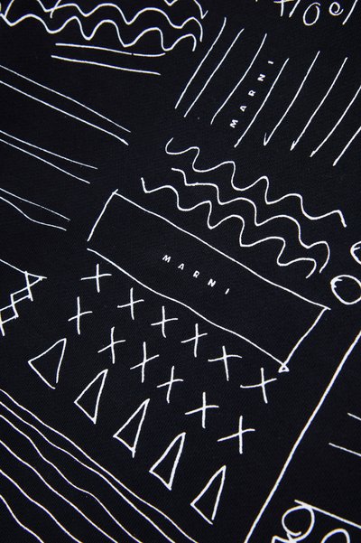 Tessuto nero con motivi astratti bianchi, tra cui linee, zigzag e forme geometriche, con il testo "MARNI" in bianco a contrasto.