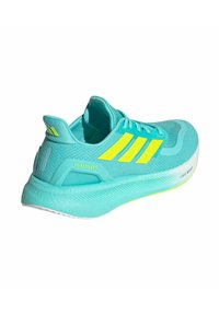 Baskets de course turquoise avec une tige en mesh texturé, trois rayures jaunes, une semelle léger boost et un col rembourré pour le confort.
