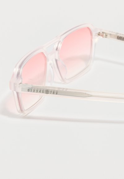 Καθαρά γυαλιά ηλίου με τετράγωνο πλαίσιο, διαφανείς ροζ φακούς με βαθμιδωτό χρώμα και διάφανα μπράτσα με αριθμημένες σημάνσεις.