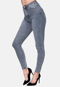 Vaqueros ajustados de cintura alta en denim gris claro con una textura suave, que presentan un diseño clásico de cinco bolsillos y un cierre de botón en la parte delantera.