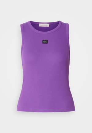 Lillat varrukatükkide top, millel on sooniline tekstuur ja ümar kaelus. Esipoolt kaunistab väike must logo silt. Sile kangas.