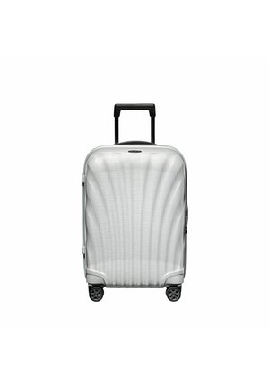 Valise en dur argentée avec un motif de vagues texturé, poignée rétractable noire et quatre roues pivotantes pour une maniabilité aisée.