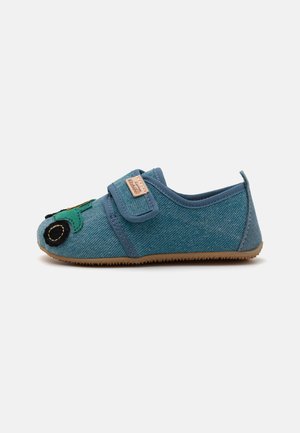 Modra tkaninska copatka z vzorcem zelenega traktorja na prstih, Velcro trak in gumijast podplat. Teksturiran material, podoben denimu.