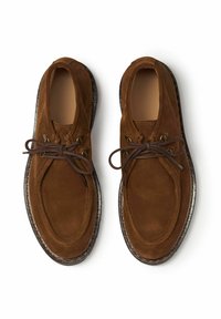Scarpe in suede marrone con punta arrotondata, design con lacci e occhielli in metallo. Presentano una suola sottile a contrasto con bordo texture.