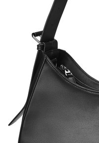 Svart läderaxelväska med en böjd form, slät textur och ett blixtlåsfack. Har en avtagbar rem och silverfärgade detaljer.