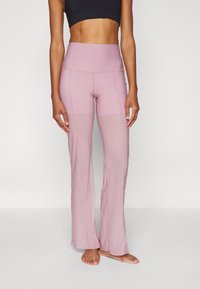 Pantalones de deporte de color rosa claro con una cinturilla alta ajustada y dobladillo acampanado. Fabricados con un material elástico, presentan una textura suave e inserciones de malla.