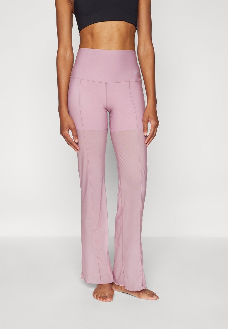 Pantalones de deporte de color rosa claro con una cinturilla alta ajustada y dobladillo acampanado. Fabricados con un material elástico, presentan una textura suave e inserciones de malla.