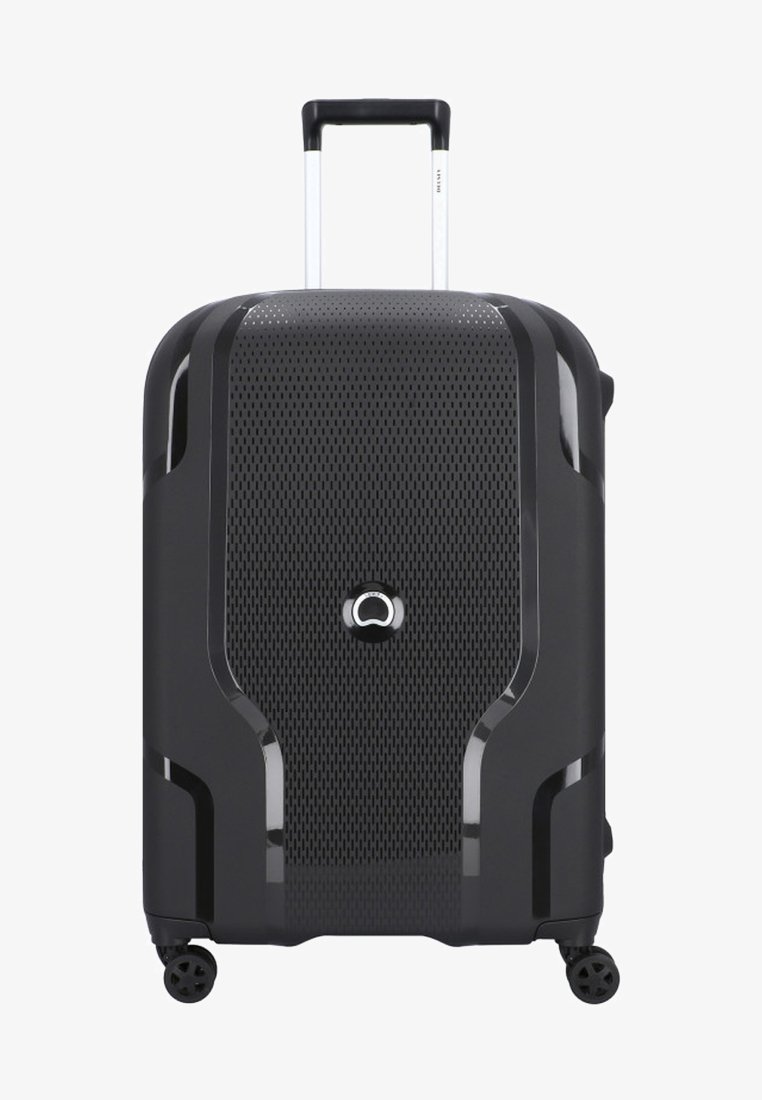 Maleta de mano rígida negra con una superficie texturada y perforada, mango telescópico plateado y cuatro ruedas negras para facilitar su movilidad.