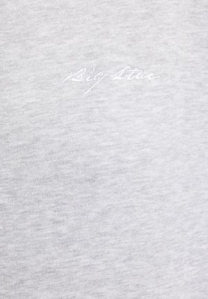 Lysegråt stof med subtilt hvidt broderet kursiv tekst, der lyder "Big Star", centreret nær toppen.