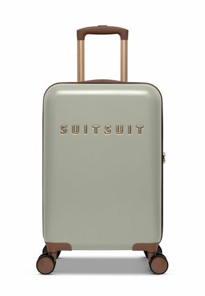 Hard-shell suitcase in light green with brown accents. Features a retractable handle, four black wheels, and the brand name embossed in gold.