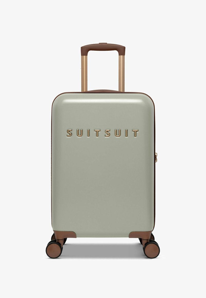 Hard-shell suitcase in light green with brown accents. Features a retractable handle, four black wheels, and the brand name embossed in gold.