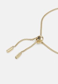 Goldkette mit einem gleitenden Perle und zwei zylindrischen Anhängern, die eine glatte Textur und zarte Glieder aufweist.