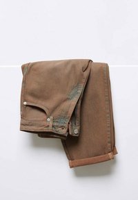 Složeny hnědé kalhoty s ohrnutými manžetami vis�ící na jednobarevném bílém pozadí, ukazující detaily přední kapsy a pasu.