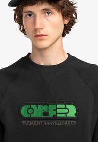 Black sweatshirt with a round neckline, featuring a green embroidered logo "CONIFER ELEMENT SKATEBOARDS" on the front. Textured detailing throughout.