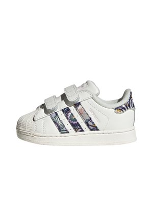 Hvid småbørns sneaker med to velcrobånd, mønstrede Adidas-striber og mønstret hælstrop på en hvid sål.