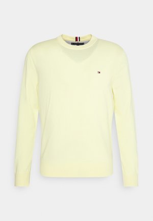 Hellgelber langärmeliger Rundhalsausschnitt-Pullover mit kleinem rot-weiß-blauem Logo auf der Brust und gestreiftem Detail im Krageninnenseite.
