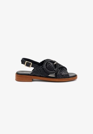 Sandal in pelle intrecciata nera con fibbia rotonda, design aperto sulla punta e tacco in legno basso. Cinturino regolabile per una vestibilità sicura.