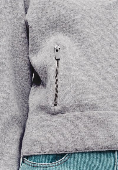 Γκρι φούτερ με πλαϊνή τσέπη με φερμουάρ, ριμπ τελείωμα και μανσέτες, με απαλή υφή και άνετη εφαρμογή.