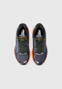 Running shoes with a dark blue mesh upper, black accents, orange soles, and bright green laces. Features textured surface and logos.