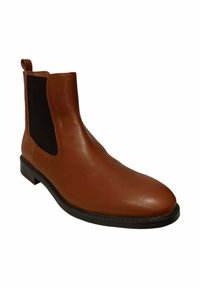 Bota Chelsea de cuero marrón con paneles laterales elásticos, puntera redondeada, textura suave y suela negra baja. Incluye una pestaña para facilitar el uso.