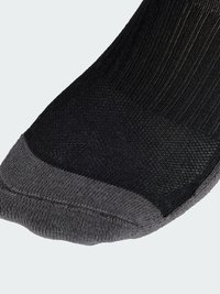 Calcetín negro con textura acanalada y una zona del dedo del pie en gris. Presenta un talón reforzado y un dedo del pie sin costuras para mayor comodidad.
