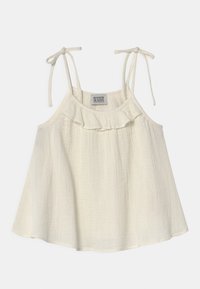 Top sin mangas de color crema claro con tirantes ajustables, escote con volantes y tejido texturizado. Diseño casual y fluido.