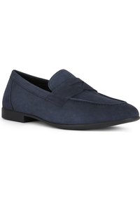 Mocassini in camoscio blu navy con suola piatta e design cucito sulla parte superiore. Presentano una punta arrotondata e una silhouette minimalista.