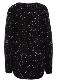 Camiseta negra de manga larga con un patrón disperso de pequeñas estrellas blancas. El material parece suave con un ajuste relajado y detalle de yugo en la parte posterior.