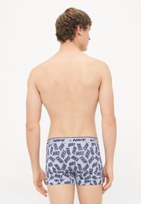 Nike férfi boxer alsónadrág világoskék színben, sötétkék logómintával. Az elasztikus derékrészén a "NIKE" márkaneve található.