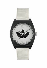 Montre rectangulaire noire avec bracelet en silicone blanc. Le cadran argenté présente un logo noir, des repères horaires à 12 et 6 heures, et un design minimaliste.